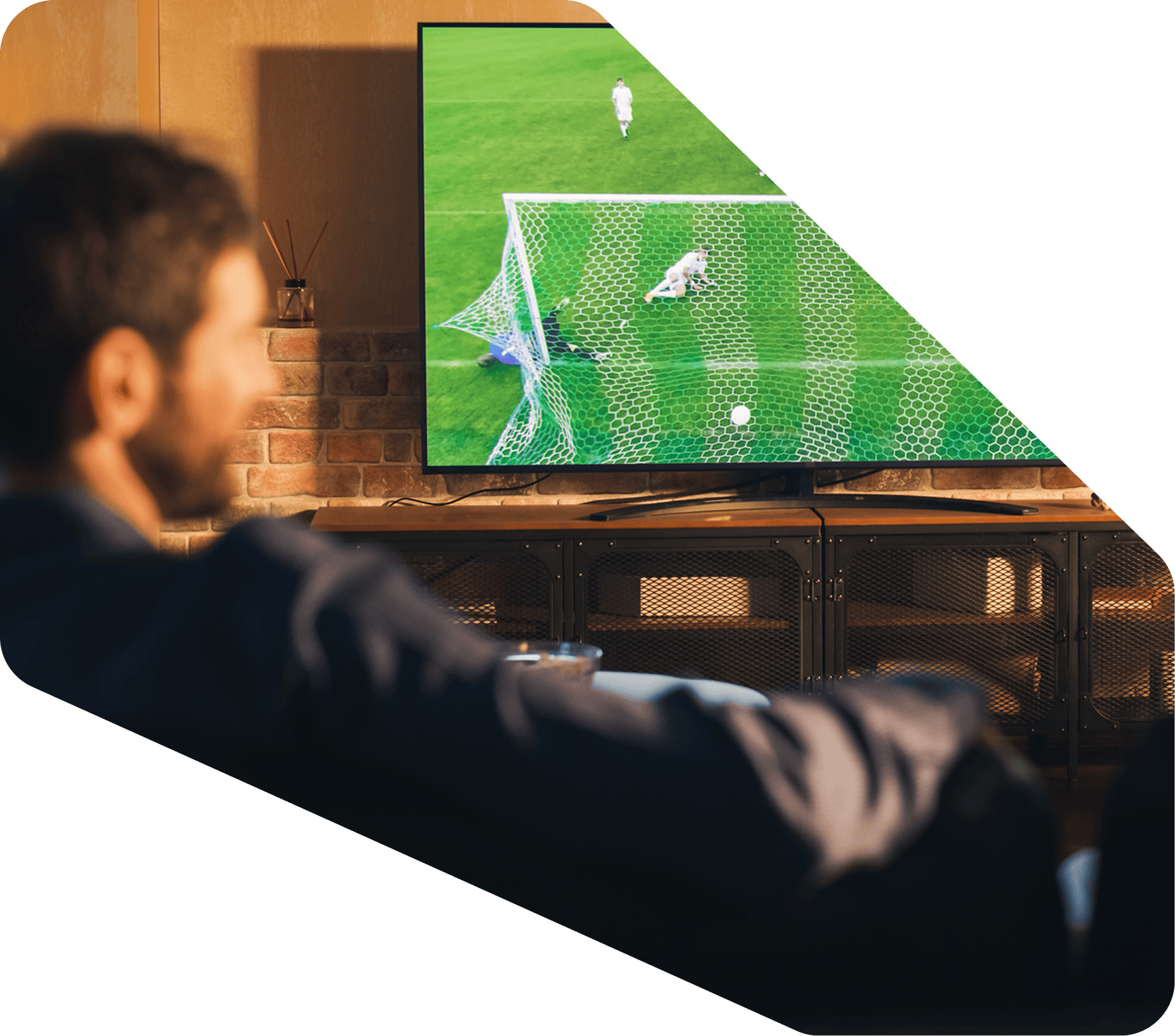 Persona viendo un partido de fútbol en la televisión